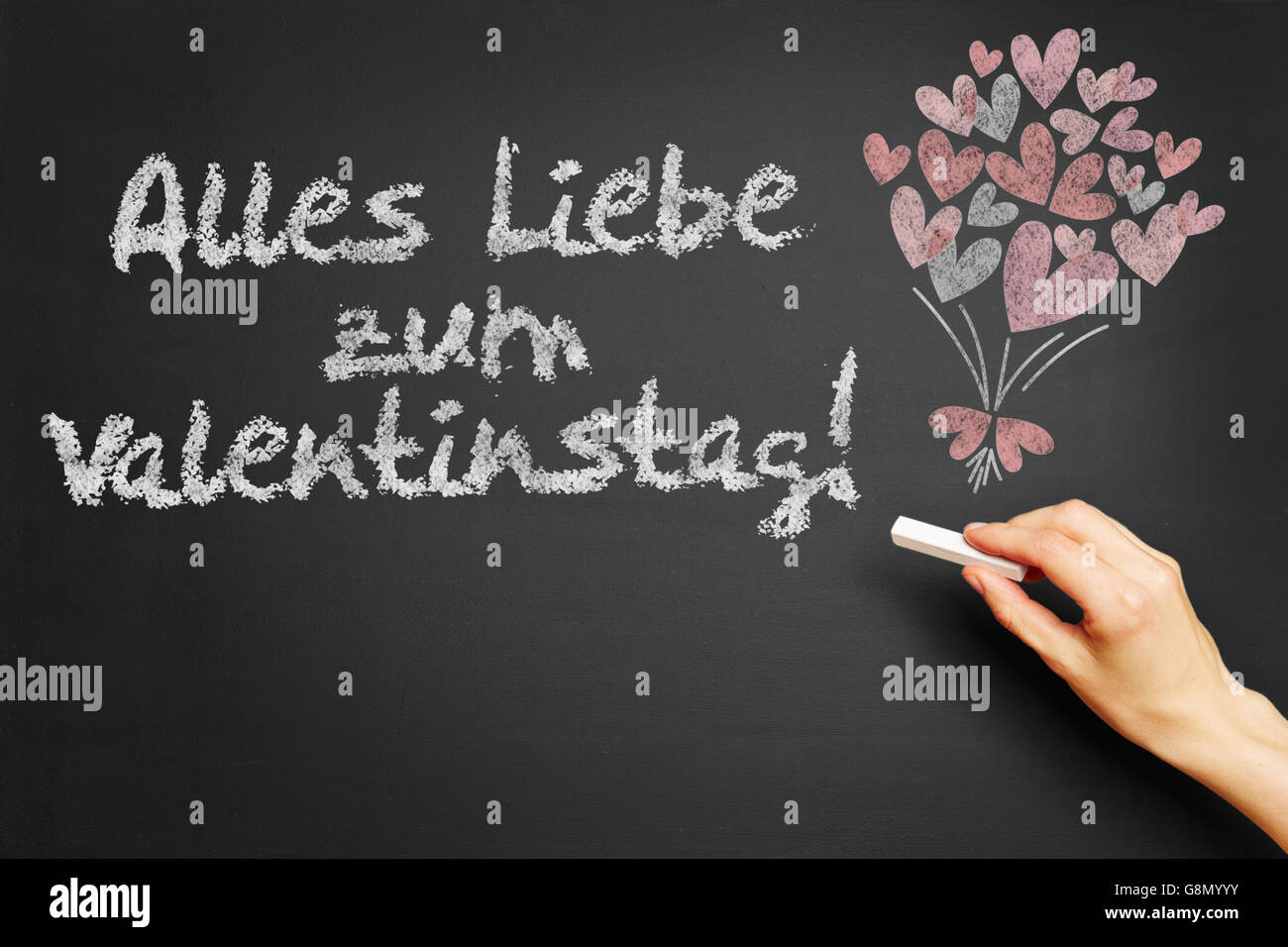 Scrive a mano in tedesco 'Alles Liebe zum Valentinstag!" (Happy Valentins giorno!) sulla lavagna Foto Stock