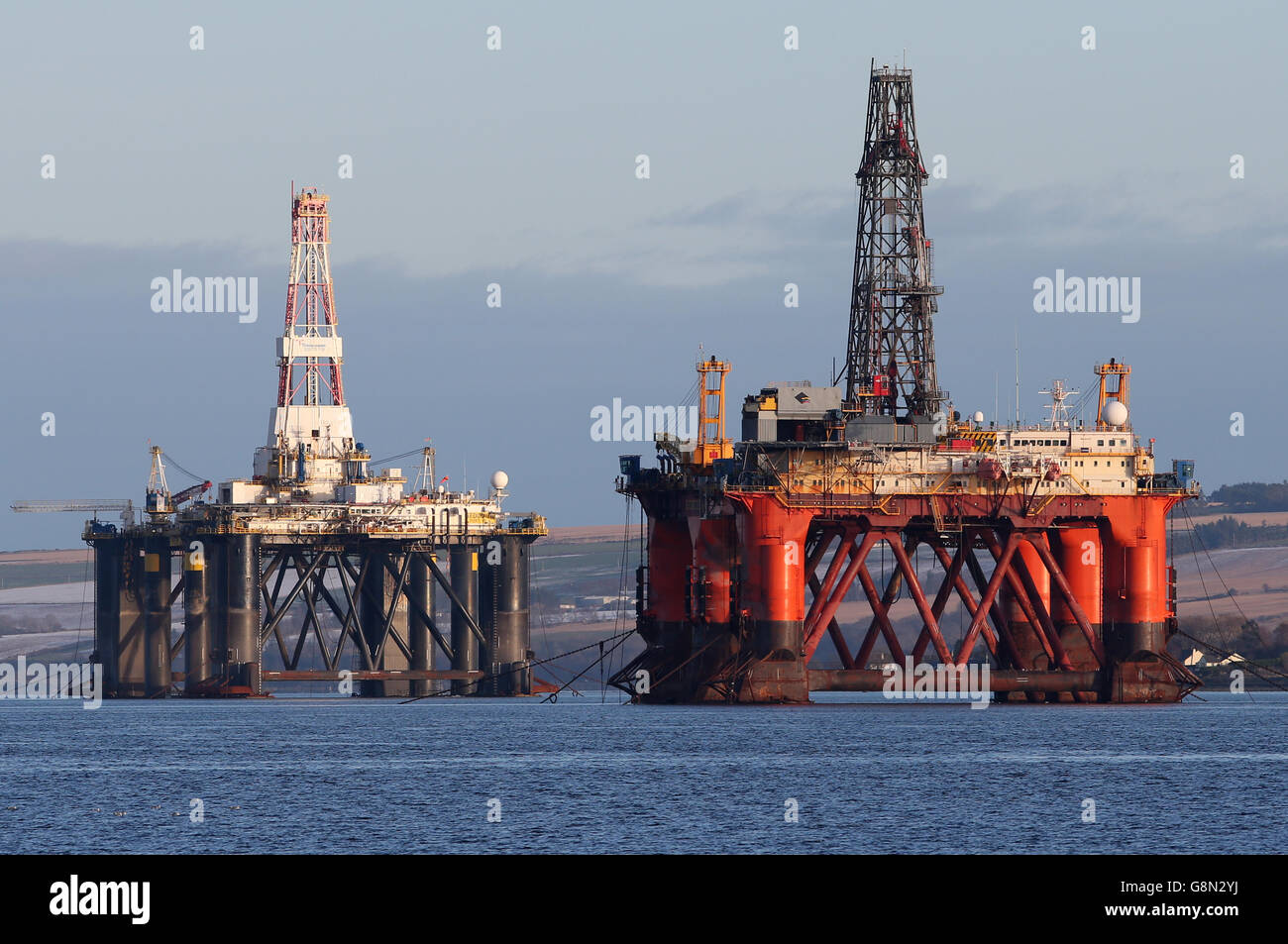 Una piattaforma petrolifera si trova tra gli altri carri che sono stati lasciati nel Cromarty Firth vicino Invergordon nelle Highlands della Scozia. Le piattaforme di perforazione sono state accatastate nel Cromarty Firth mentre i prezzi del petrolio continuano a diminuire, avendo un impatto importante sull'industria petrolifera del Mare del Nord del Regno Unito, lasciando migliaia di persone fuori lavoro. Foto Stock