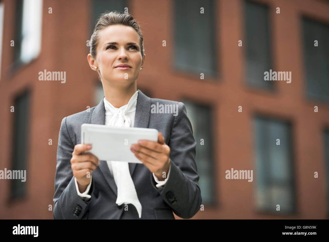 Il nuovo business. Moderno business donna con tablet PC contro l edificio per uffici Foto Stock