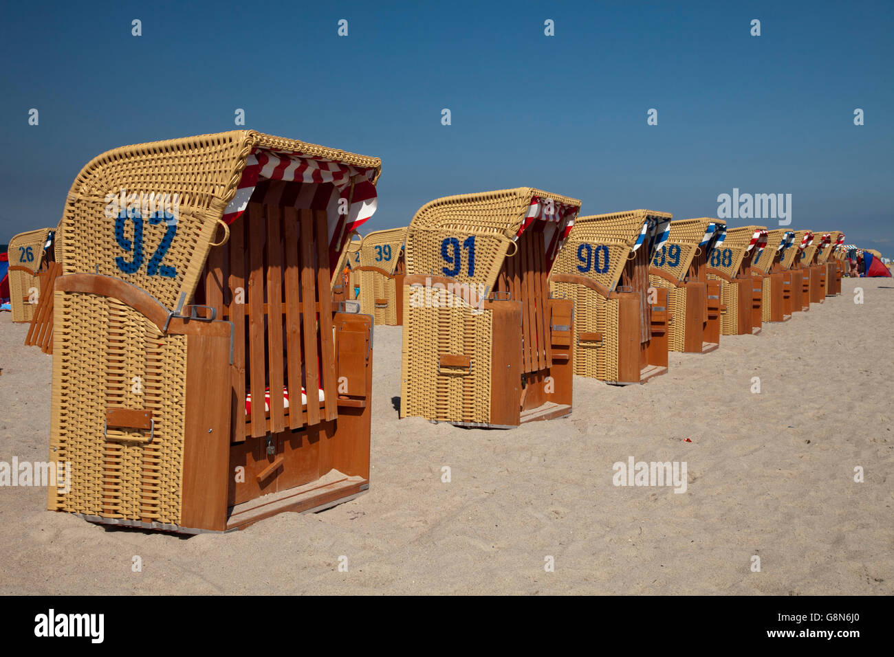 Coperto e sedie da spiaggia in vimini in una fila sulla spiaggia del Mar Baltico località di Timmendorf, isola di Poel Foto Stock