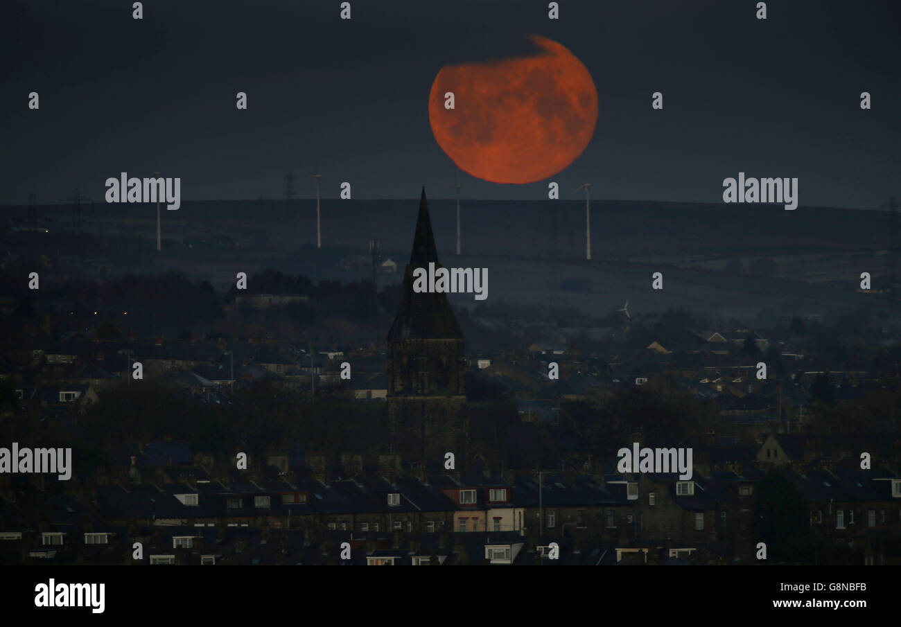 Meteo invernale 23 febbraio 2016. Una luna piena tramonta su Bradford, West Yorkshire. Foto Stock