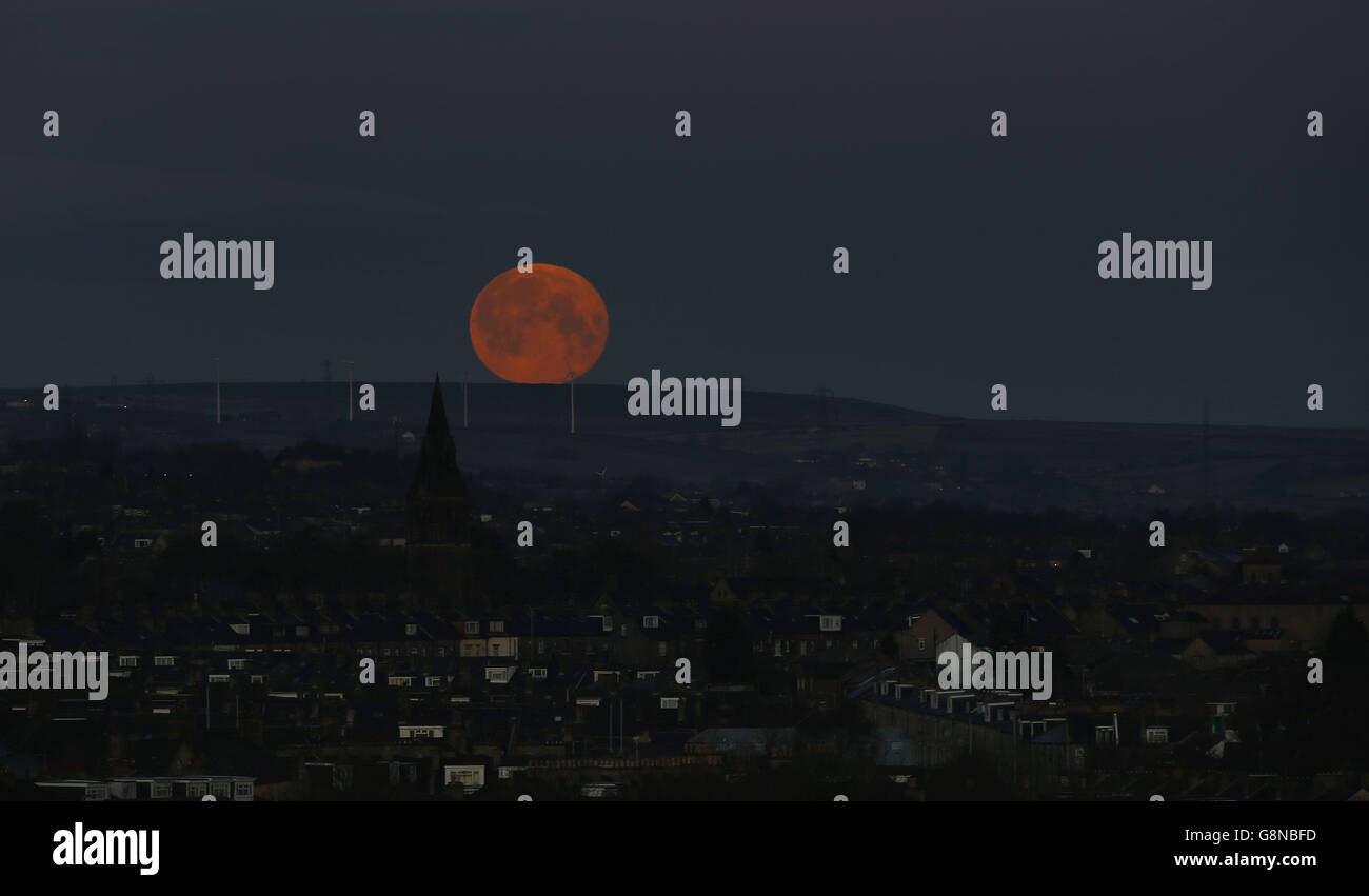 Meteo invernale 23 febbraio 2016. Una luna piena tramonta su Bradford, West Yorkshire. Foto Stock