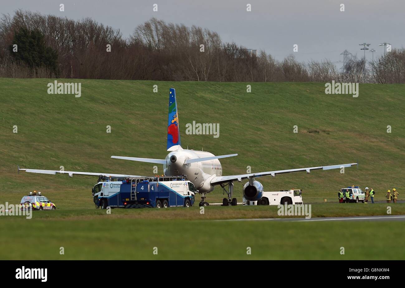 Le squadre di soccorso e di fuoco recuperano un Airbus A320 che è andato fuori dalla pista e ha finito sulla verga dopo l'atterraggio all'aeroporto di Birmingham. Foto Stock