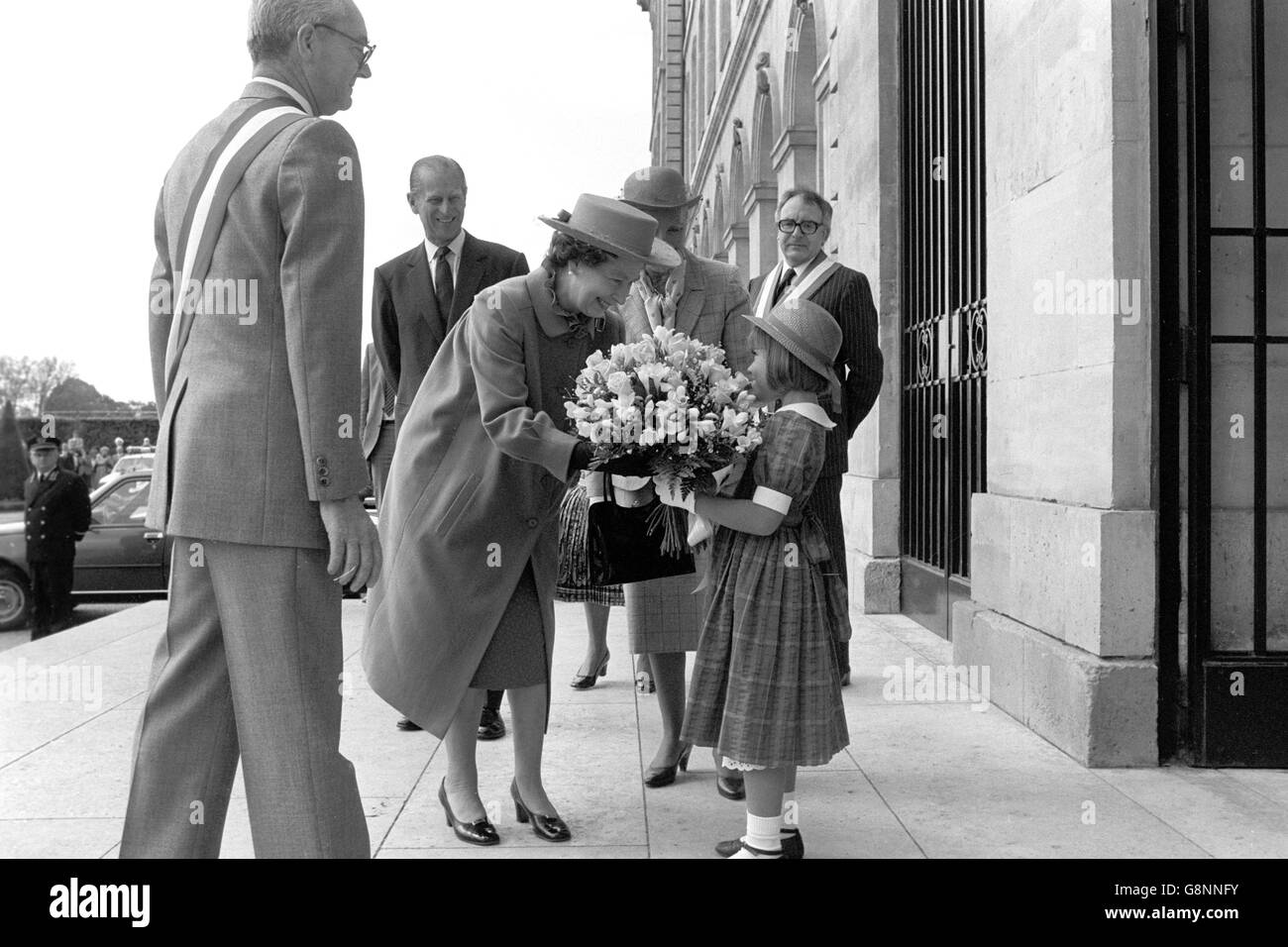 Emilie, 7 anni, nipote di Jean-Marie Girault, Sindaco di Caen, presenta con orgoglio un bouquet alla Regina al suo arrivo all'Hotel de Ville per le celebrazioni del D-Day di oggi. Sullo sfondo è il Duca di Edimburgo. Foto Stock