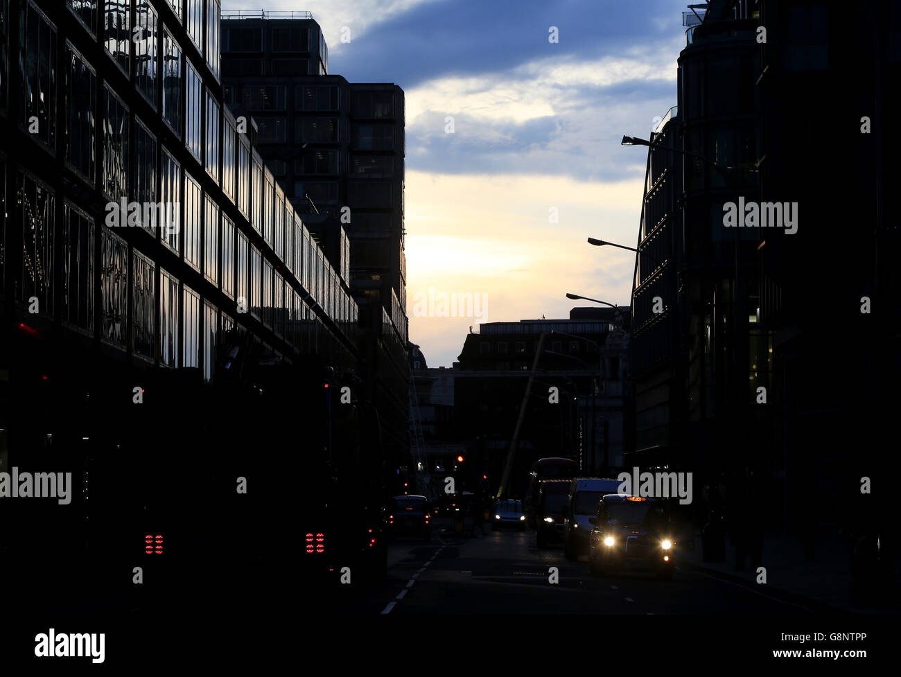Il traffico si sposta lungo Victoria Street mentre il sole tramonta dietro la stazione ferroviaria di Victoria a Londra. Foto Stock