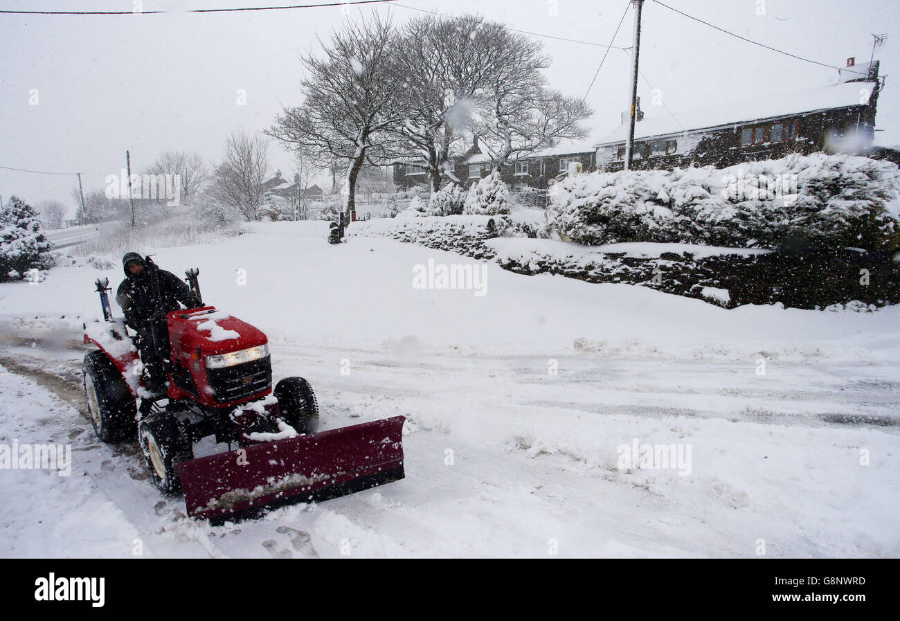 Le case e le strade lottano per eliminare la neve pesante che è caduta su Saddleworth vicino Oldham, poiché alcune parti del Regno Unito si sono svegliate fino a quasi quattro centimetri di neve venerdì mattina, mentre marzo continua a sentirsi più come l'inverno che la primavera. Foto Stock