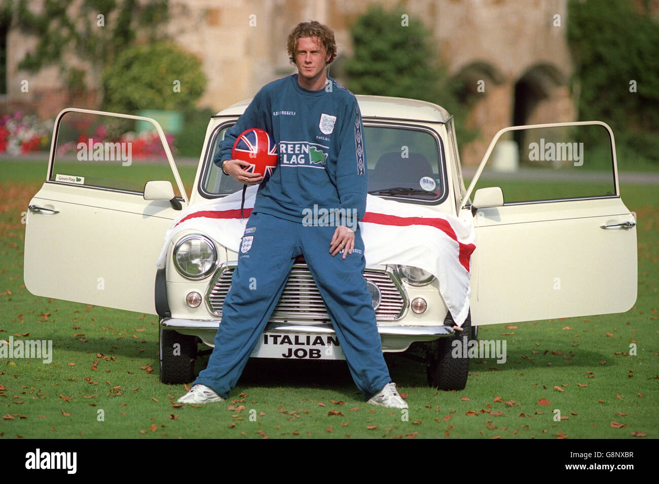 Liverpool winger Steve McManaman a Bisham Abbey dopo l'allenamento con il team inglese. Sta posando con una Mini simile alla famosa auto usata nel film 'il lavoro Italiano'. Foto Stock