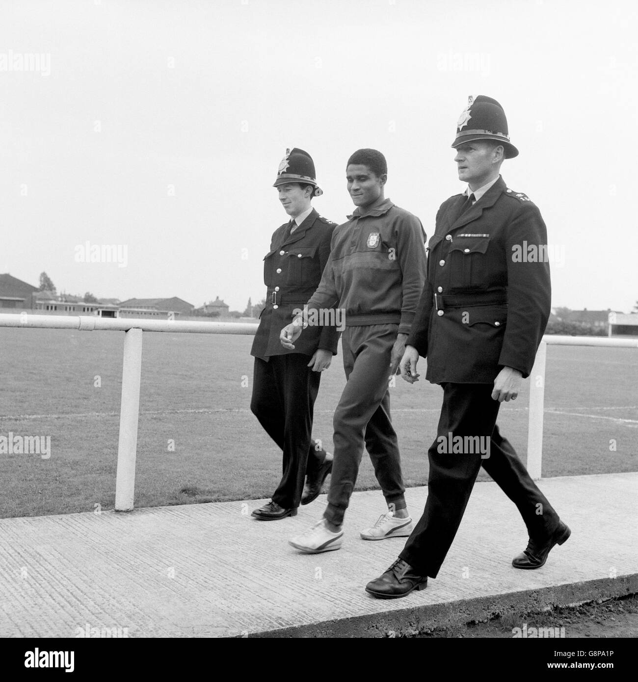 Calcio - Coppa del mondo Inghilterra 1966 - Portogallo Training. Eusebio (c) del Portogallo viene consegnato alla fine della formazione un accompagnatore di polizia al pullman della squadra Foto Stock