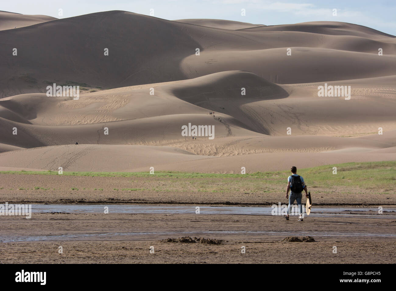 Colorado, San Luis Valley, Grande dune sabbiose del Parco Nazionale. Uomo con scheda di sabbia. Foto Stock