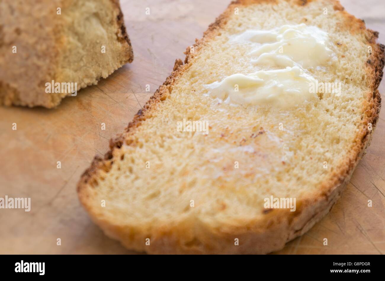 Fondere il burro su una fetta di rustico pane tostato Foto Stock