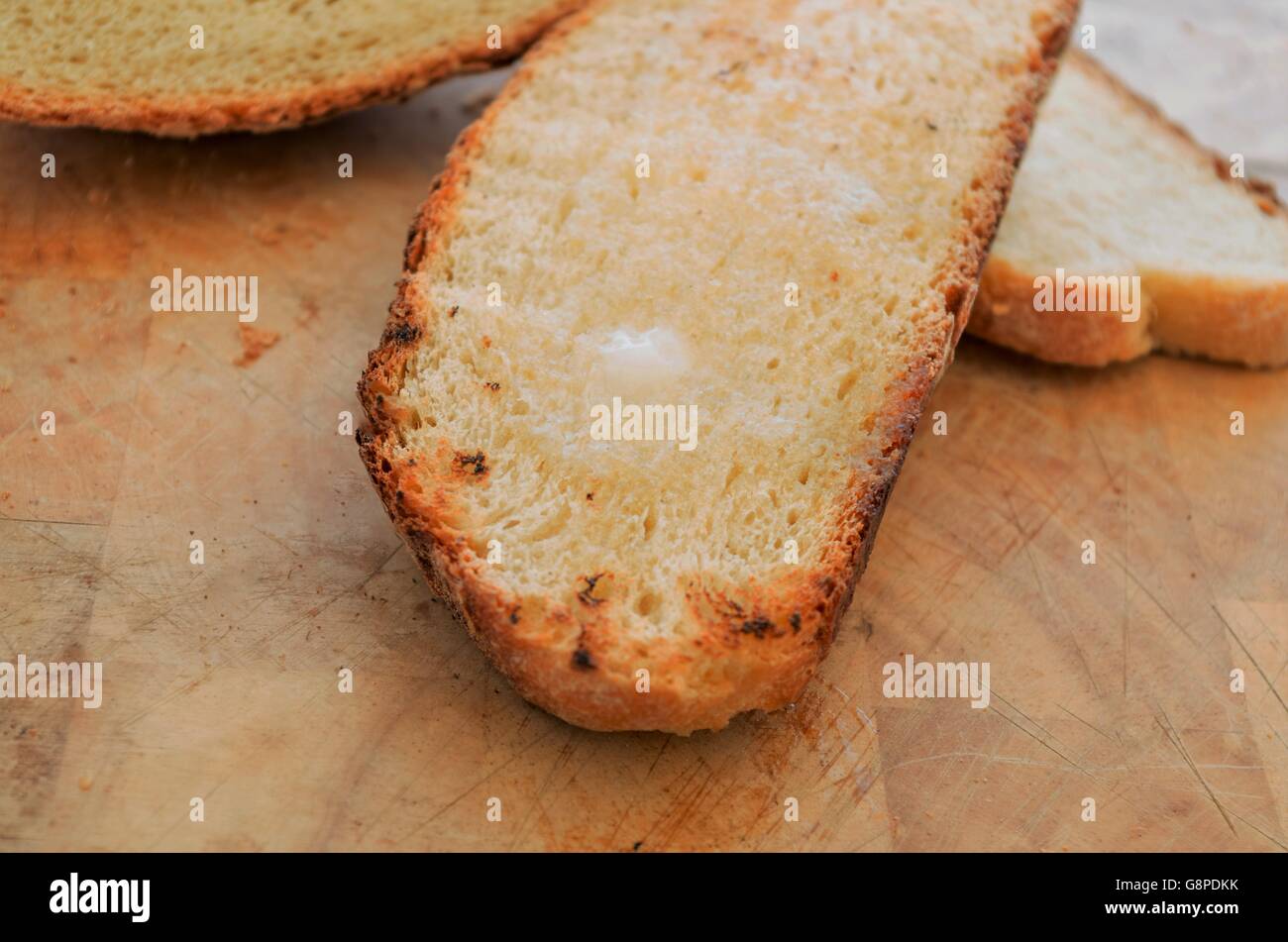 Fondere il burro su una fetta di rustico pane tostato Foto Stock