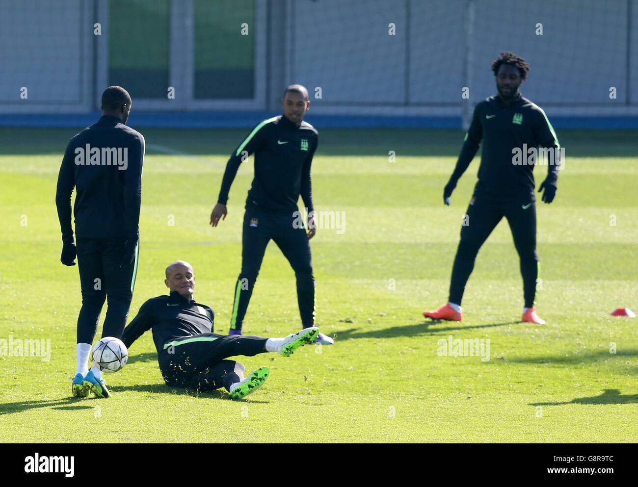 Vincent Kompay (seconda a sinistra) di Manchester City tenta un'azione di prova durante una sessione di allenamento alla City Football Academy di Manchester. Foto Stock