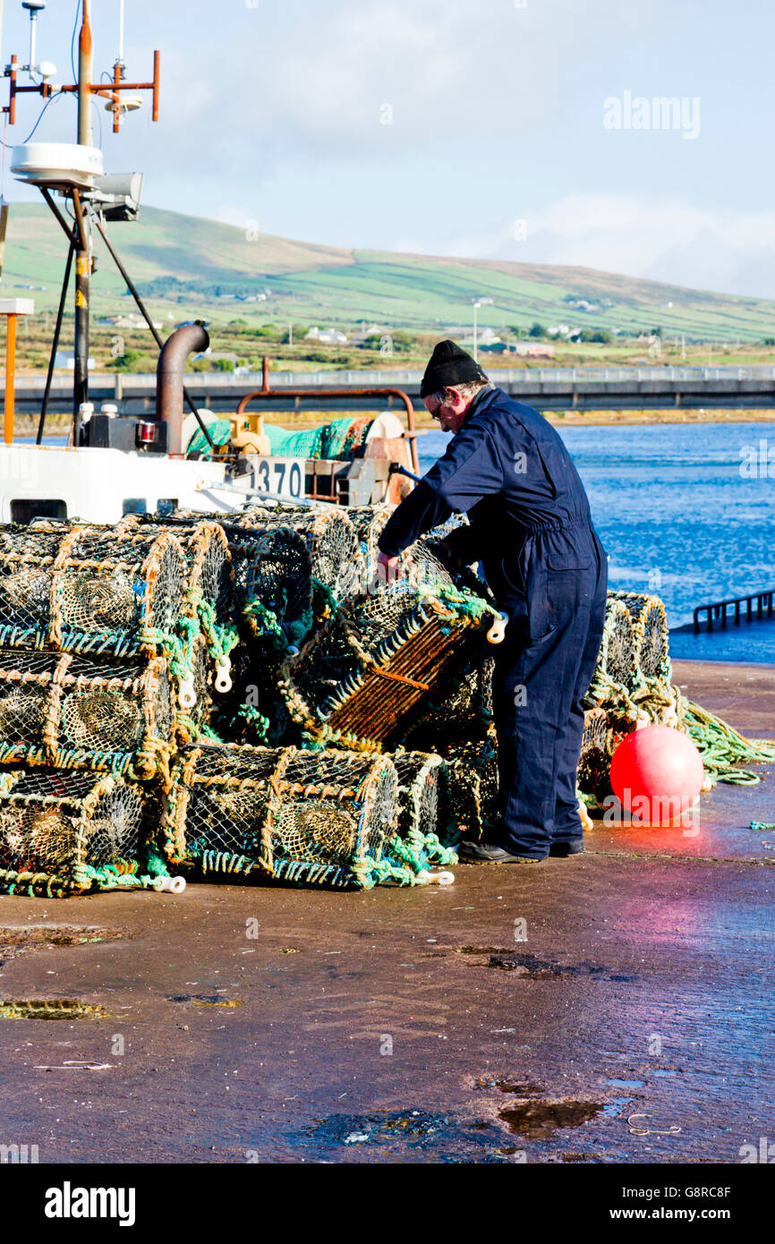 Un pescatore locale pile lobster pentole sul molo di Portmagee nella Contea di Kerry Irlanda, Europa. Foto Stock