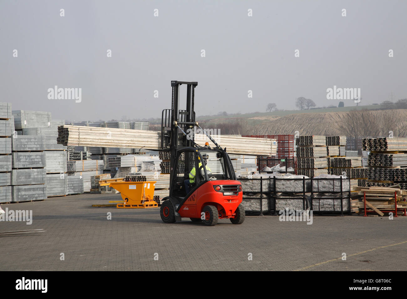 Un carrello elevatore a forche si muove lungo le travi in una grande costruzione Cantiere attrezzature Foto Stock