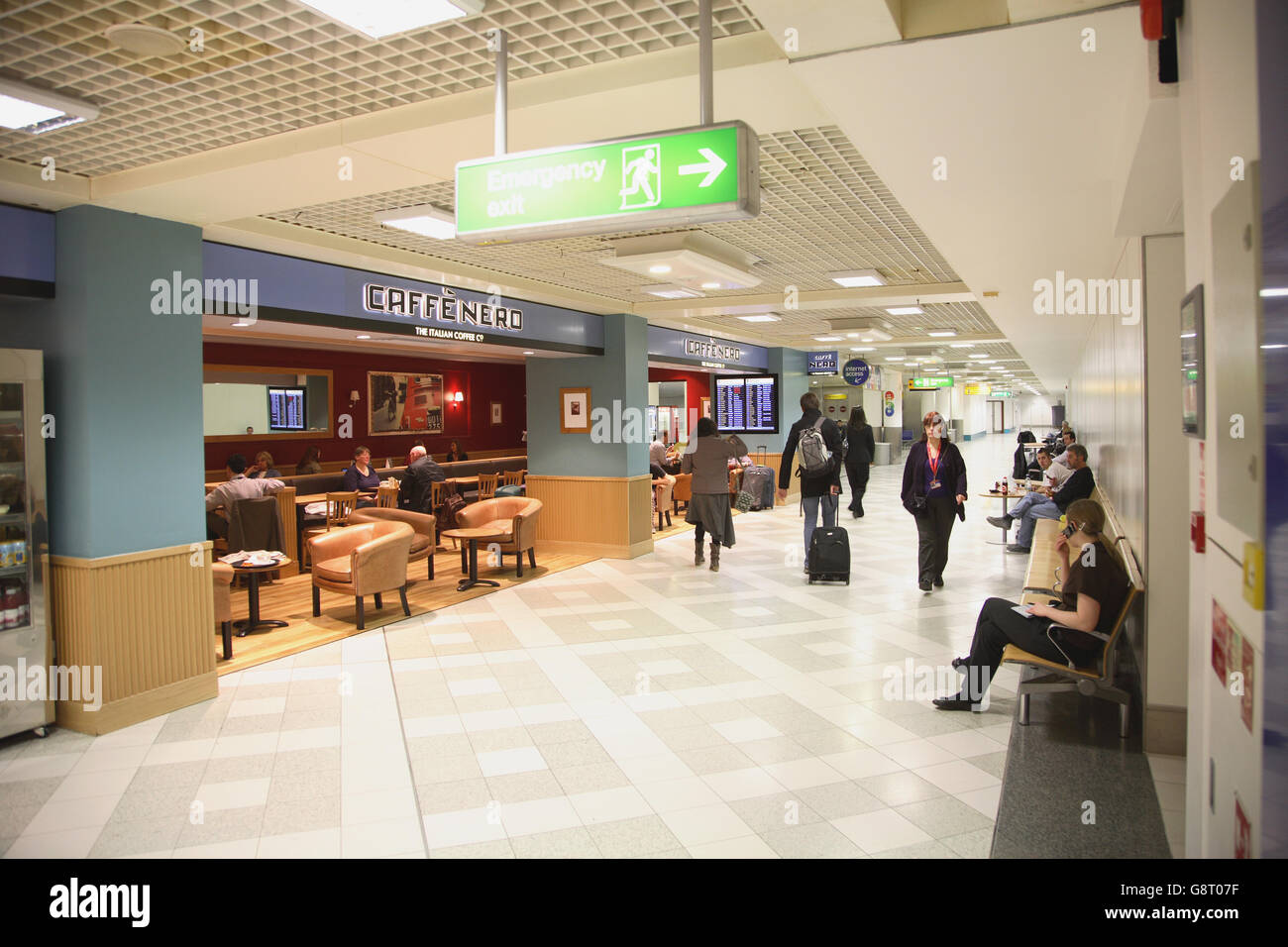 Land-lato bar caffè all aeroporto di Gatwick South Terminal. Mostra i passeggeri con bagagli seduto e passeggiate Foto Stock