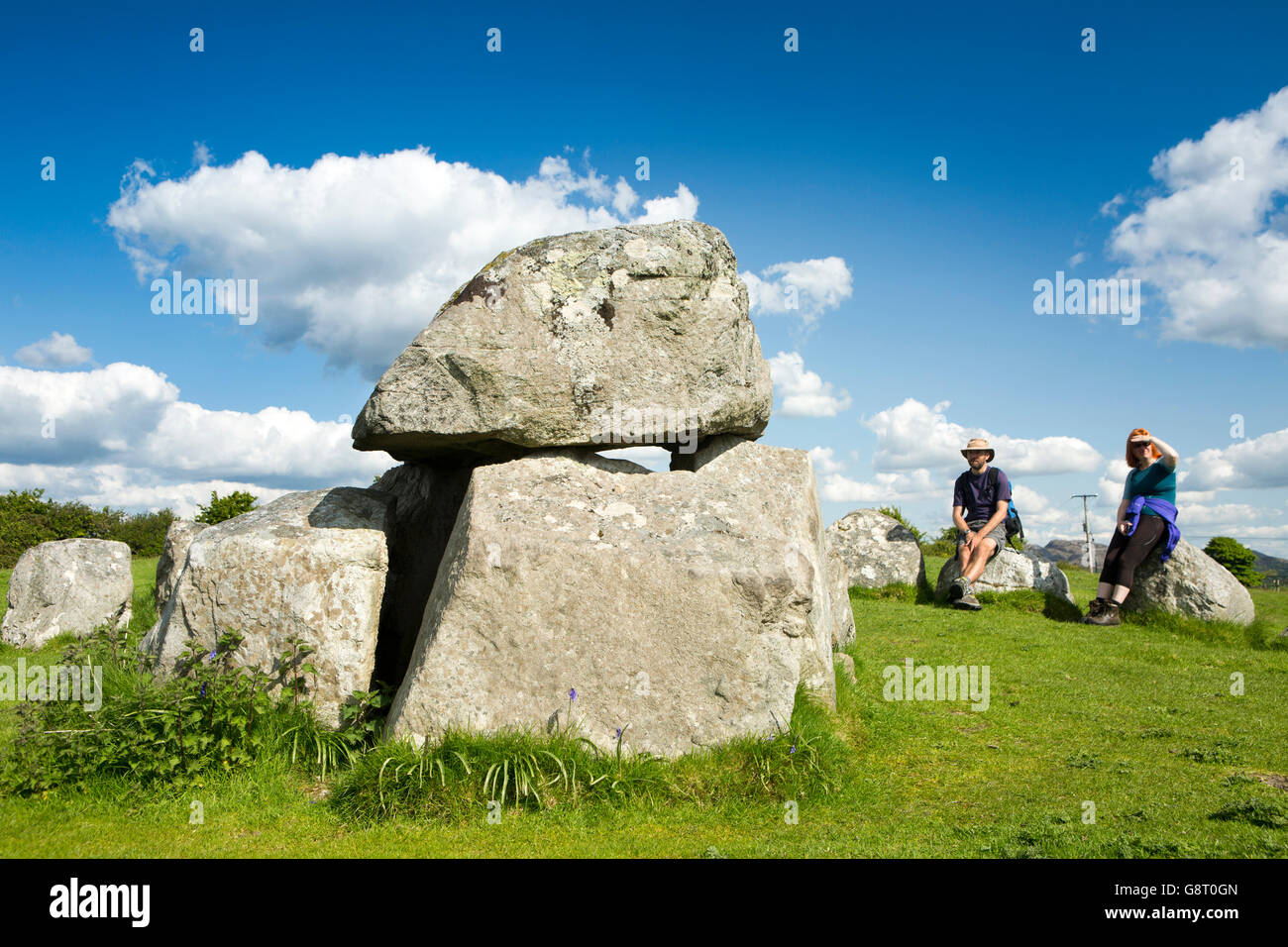 Irlanda, Co Sligo, Cimitero Megalitico di Carrowmore, giovane seduto sul cerchio di pietra intorno al dolmen Foto Stock