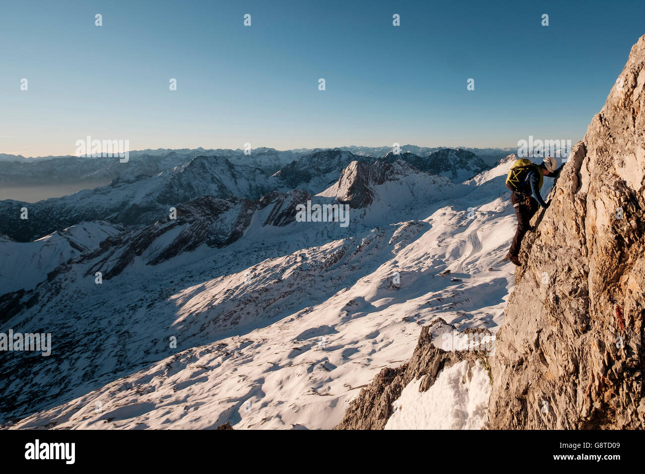 Lone alpinista salendo ripida parete nelle Alpi europee Foto Stock