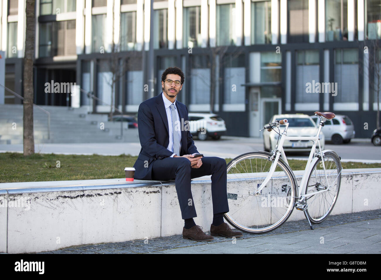 Imprenditore con bicicletta prendendo una pausa in città Foto Stock
