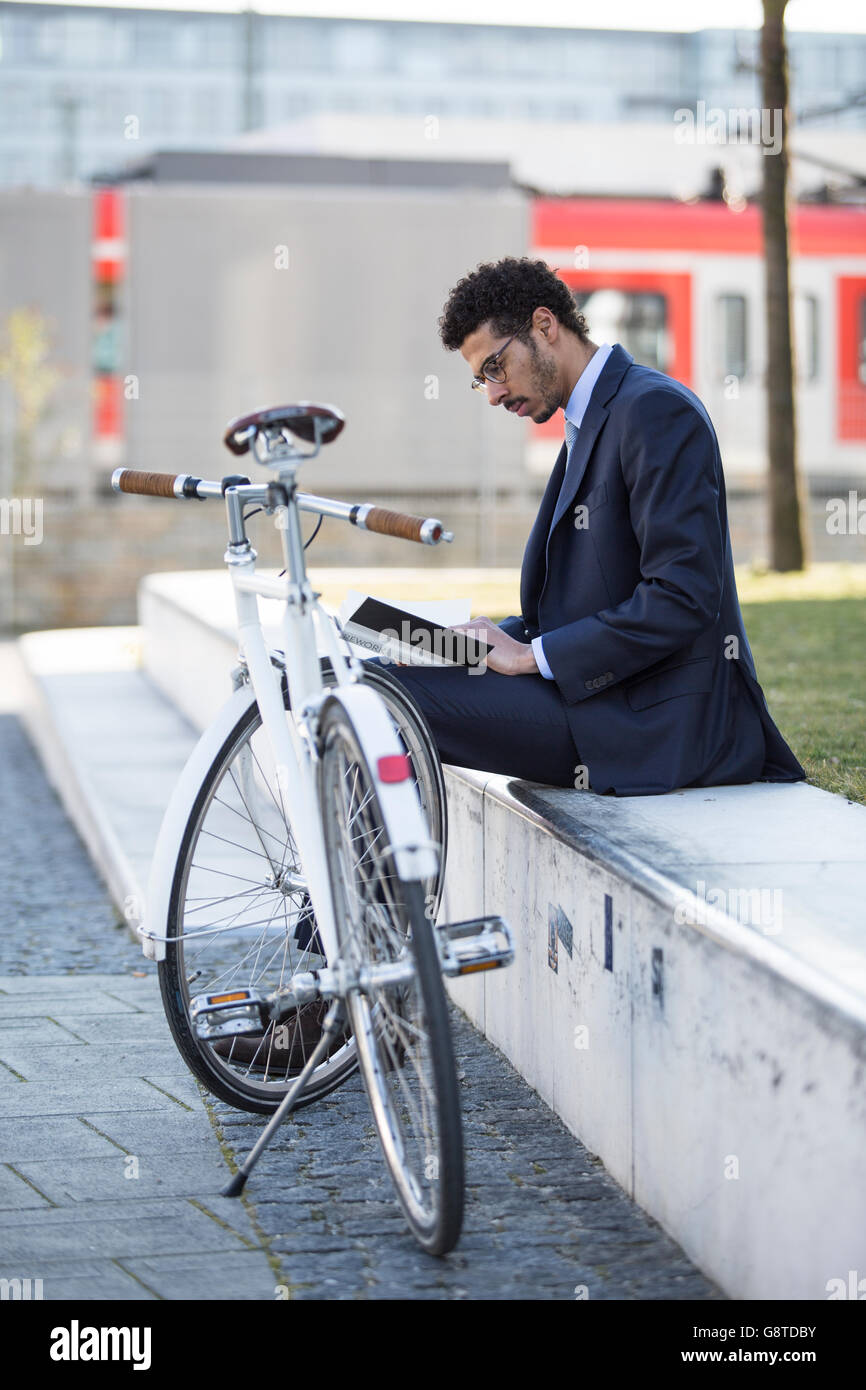 Imprenditore con bicicletta prendendo una pausa in città Foto Stock