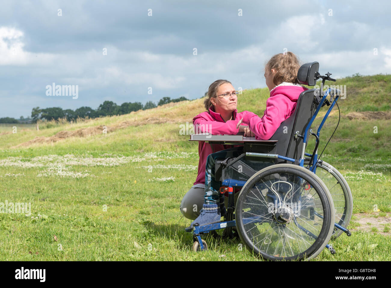 Un disabile su sedia a rotelle rilassarsi con l aiuto di un volontario lavoratore di cura Foto Stock
