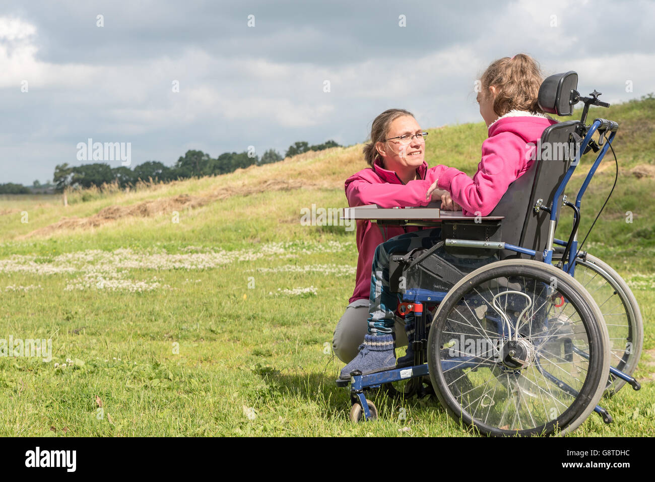 Un disabile su sedia a rotelle rilassarsi con l aiuto di un volontario lavoratore di cura Foto Stock
