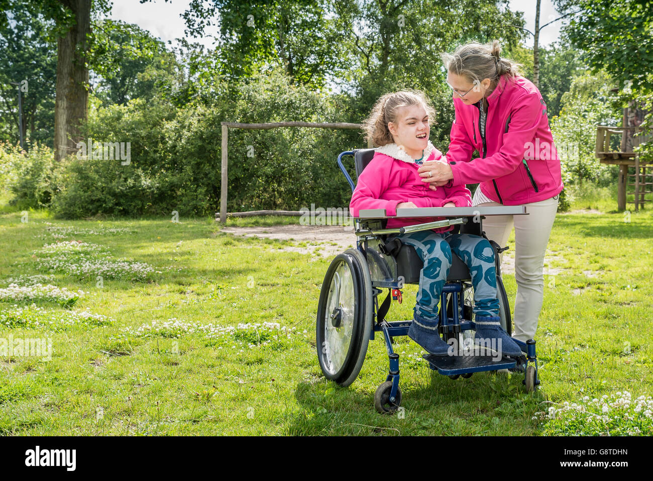 Un disabile su sedia a rotelle rilassarsi con l aiuto di un volontario lavoratore di cura Foto Stock