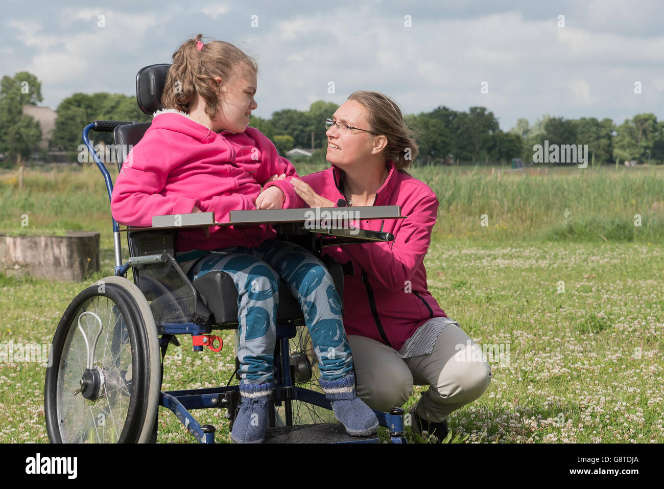 Un disabile su sedia a rotelle rilassarsi con l aiuto di un volontario lavoratore di cura Foto Stock