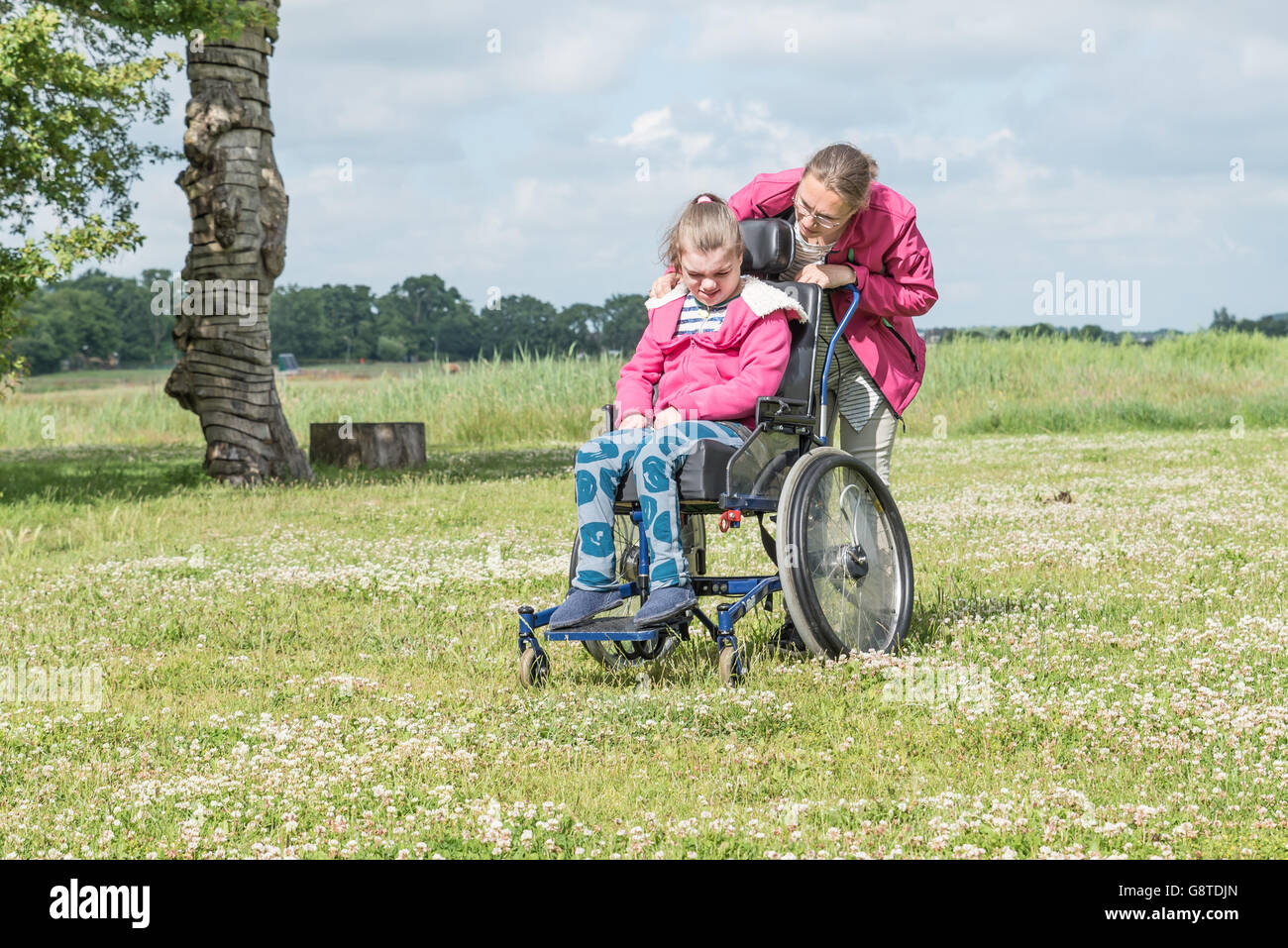 Un disabile su sedia a rotelle rilassarsi con l aiuto di un volontario lavoratore di cura Foto Stock