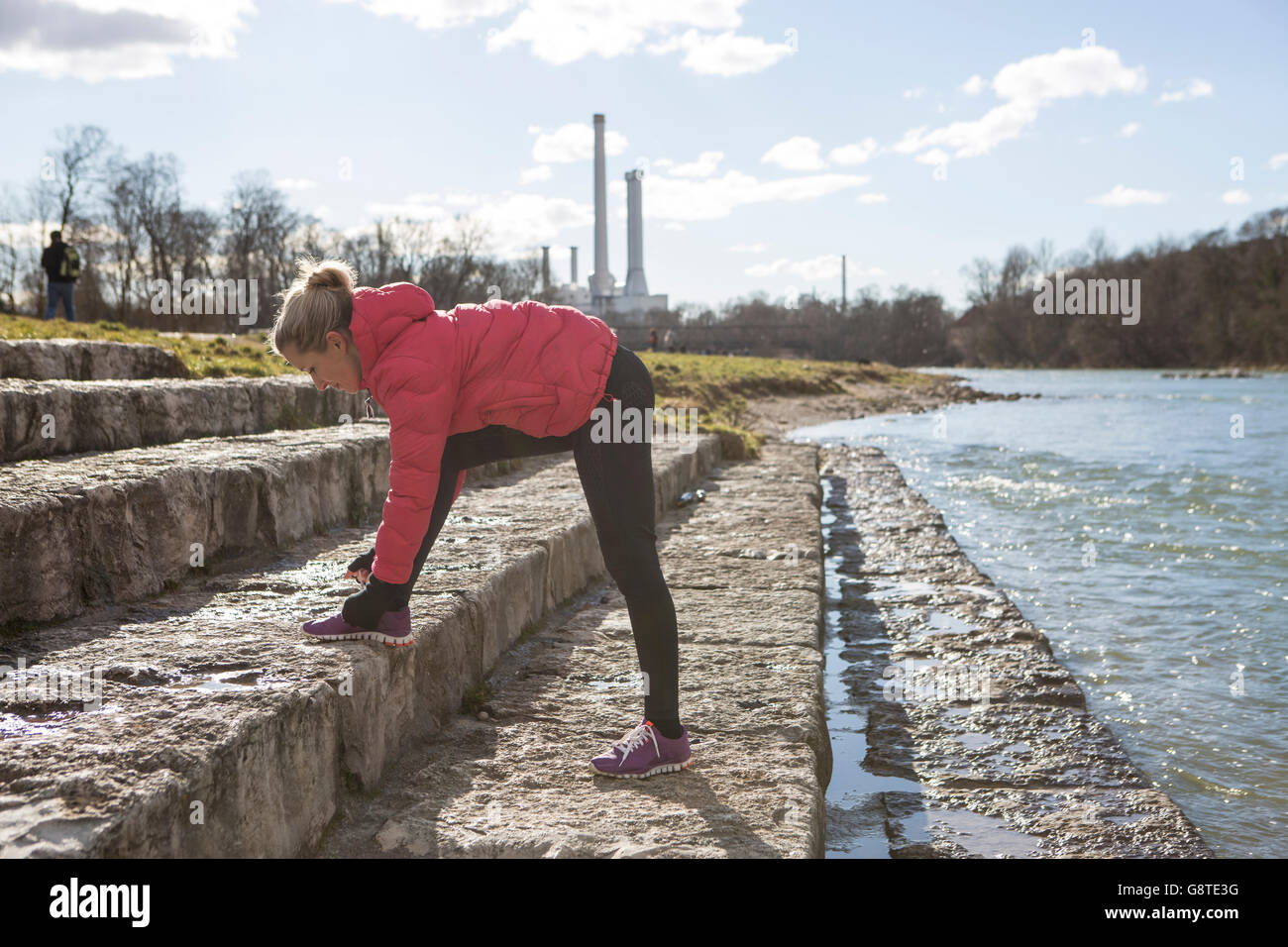 Donna bionda legatura di calzatura sportiva merletto a Riverside Foto Stock