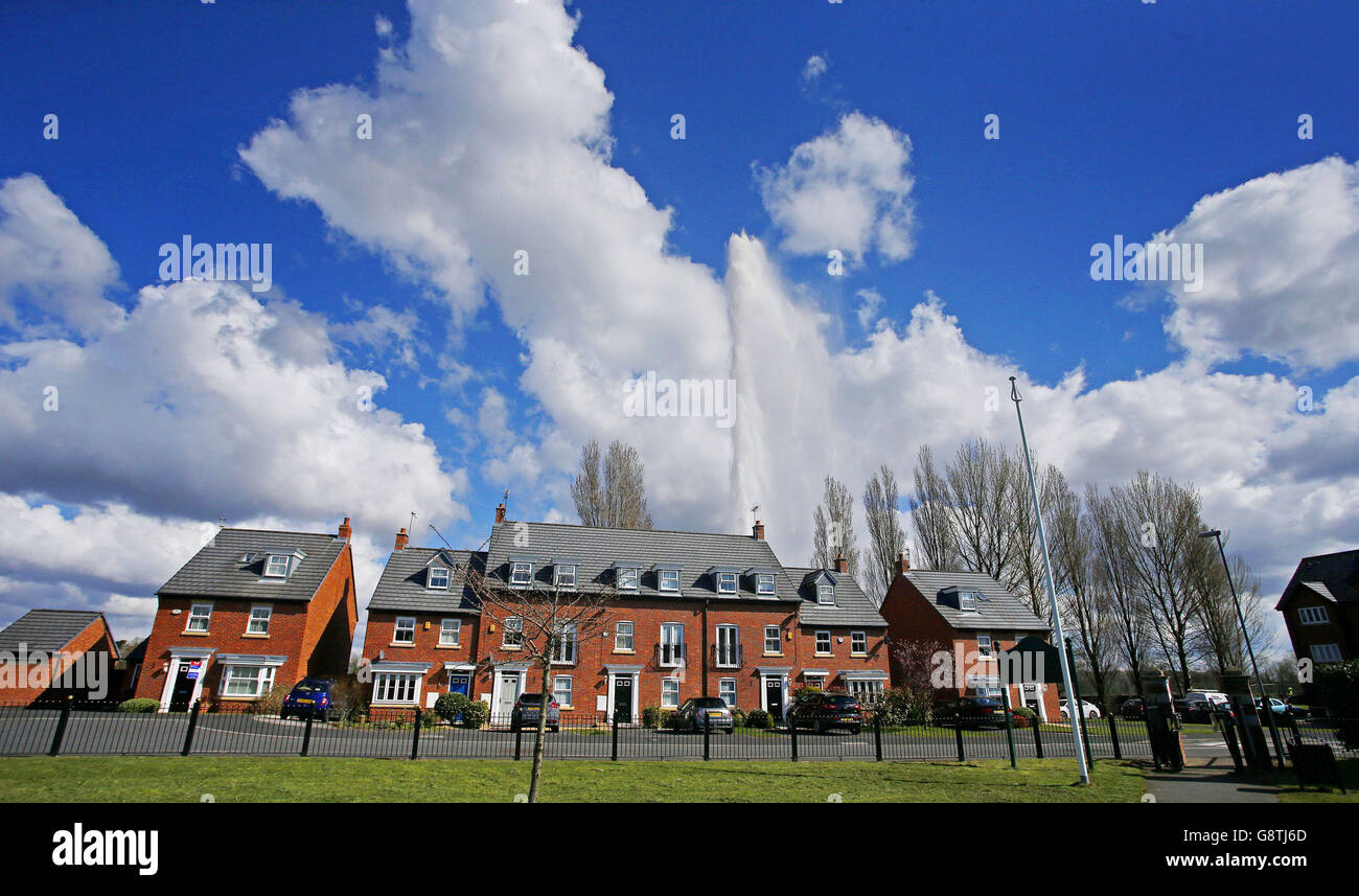 Un'acqua di scoppio principale su un cantiere spruzzi acqua che raggiunge le altezze di circa 120 piedi, dietro le case in Halewood, Knowsley. Foto Stock