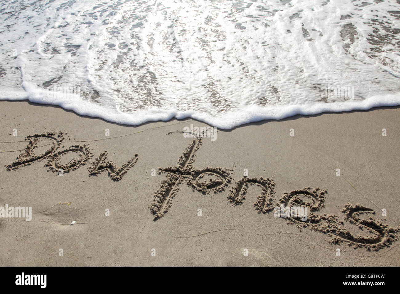 Dow Jones il testo scritto nella sabbia di una spiaggia Foto Stock