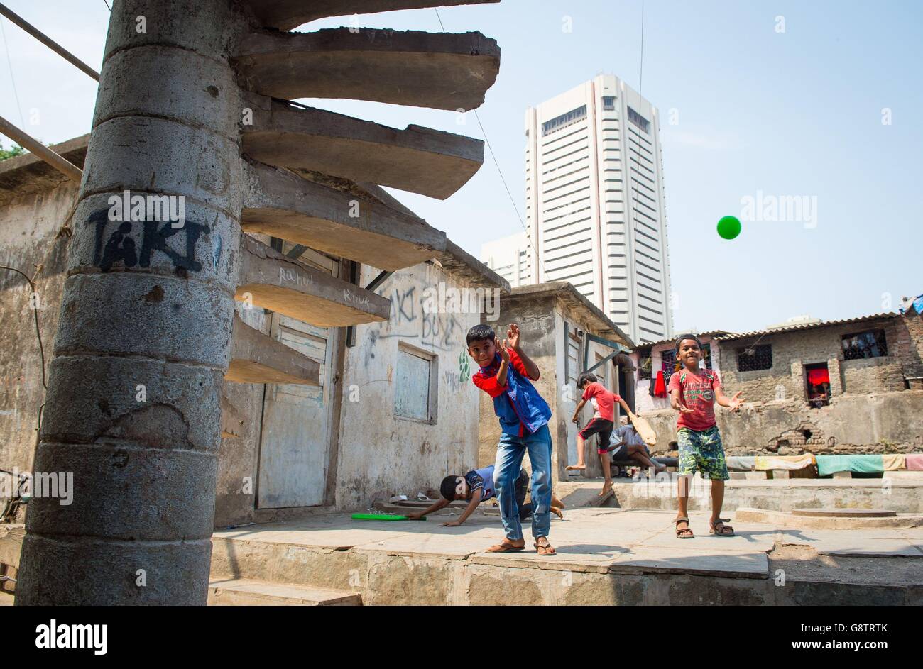 I ragazzi giocano una partita di cricket nella zona di baraccopoli di Anbedkar Nagar a Mumbai, India. Foto Stock