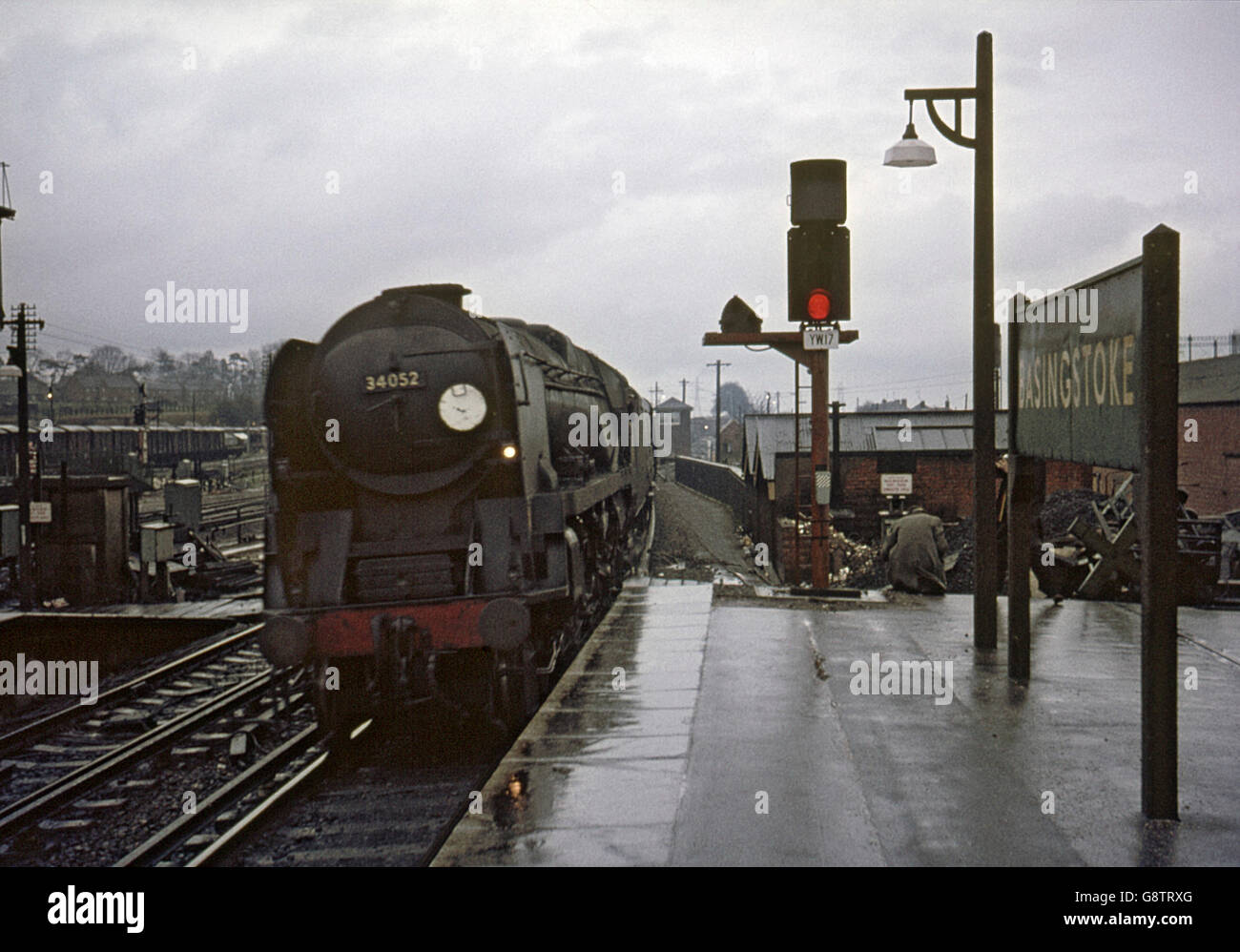 La pioggia batte incessantemente come Bulleid Pacific n. 34052 Signore Dowding arriva a Basingstoke in corrispondenza della testa di un semi-fast fr Foto Stock