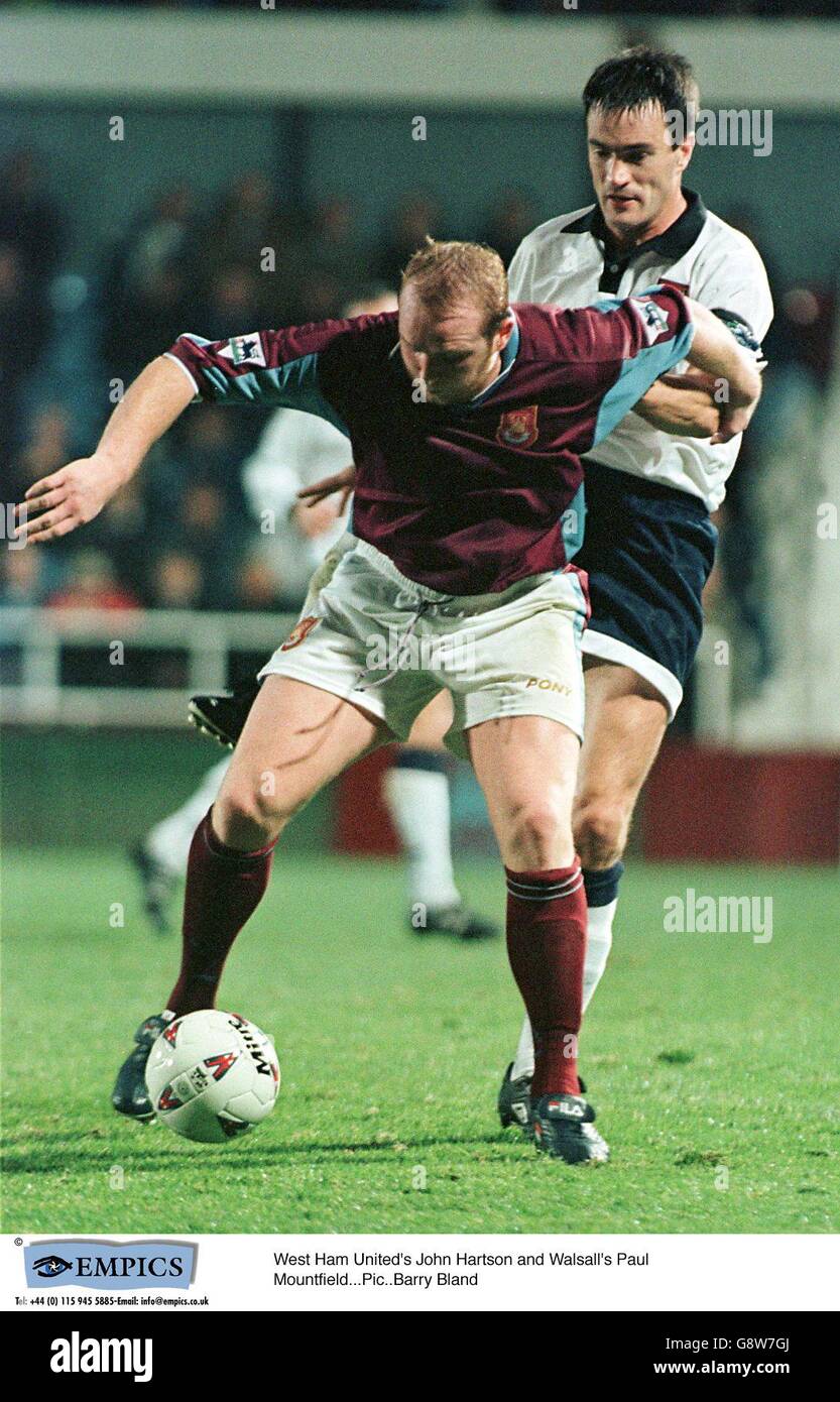 John Hartson di West Ham United (a sinistra) protegge la palla da Walsall's Derek Mountfield (a destra) Foto Stock