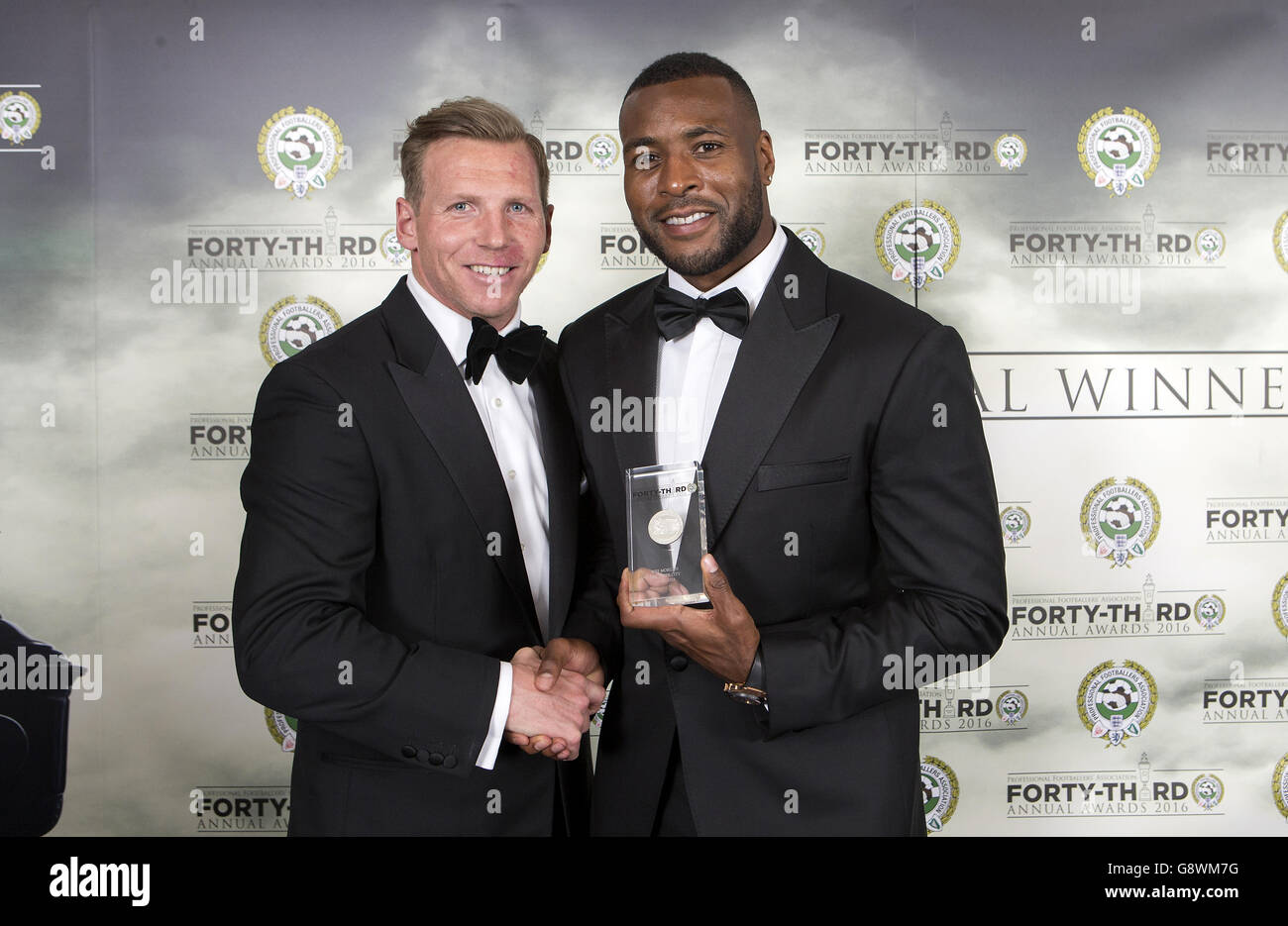 Il presidente della Professional Footballers' Association Ritchie Humphreys (a sinistra) presenta il Wes Morgan di Leicester City con il suo premio PFA Premier League Team of the Year durante i PFA Awards al Grosvenor House Hotel di Londra. Foto Stock