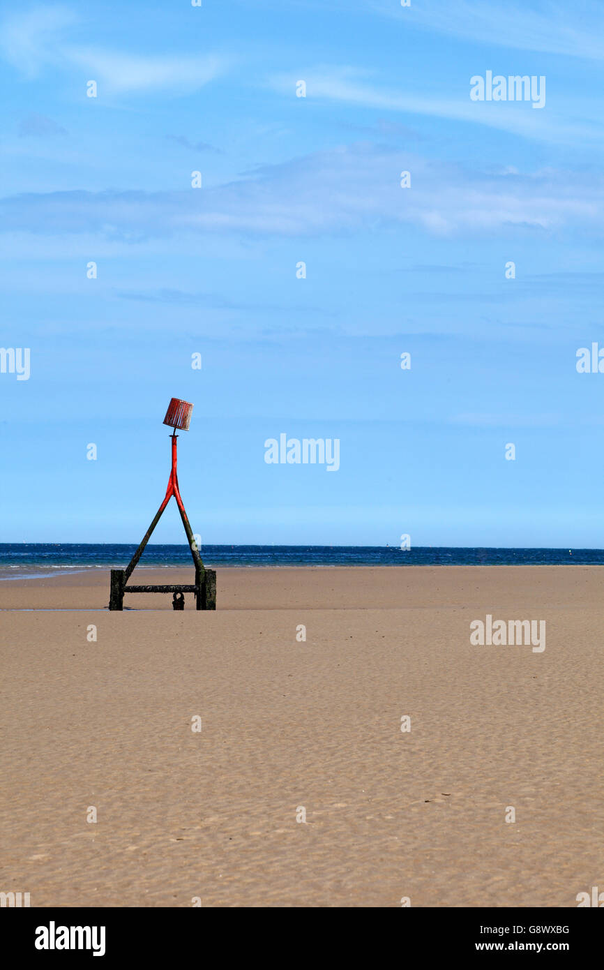 Spiaggia sul marcatore Redcar Beach, Cleveland, nel nord est dell'Inghilterra, Regno Unito. Un fisso groyne navigazione marker aiuti per la guida di imbarcazioni. Foto Stock