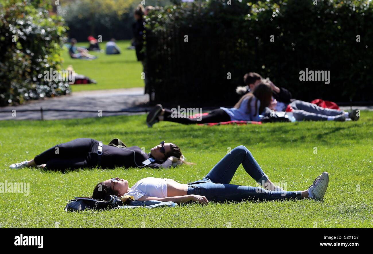 La gente si rilassa a St Stephens Green, Dublino, mentre il bel tempo continua attraverso il Regno Unito e l'Irlanda. Foto Stock