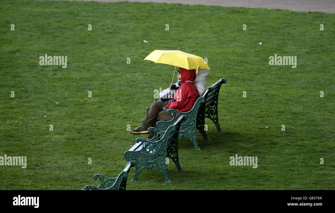 Racegoers rifugio dalla pioggia all'ippodromo di Ascot, Berkshire. PREMERE ASSOCIAZIONE foto. Data immagine: Mercoledì 27 aprile 2016. Guarda la storia di PA RACING Ascot. Il credito fotografico dovrebbe essere: Steve Parsons/PA Wire Foto Stock