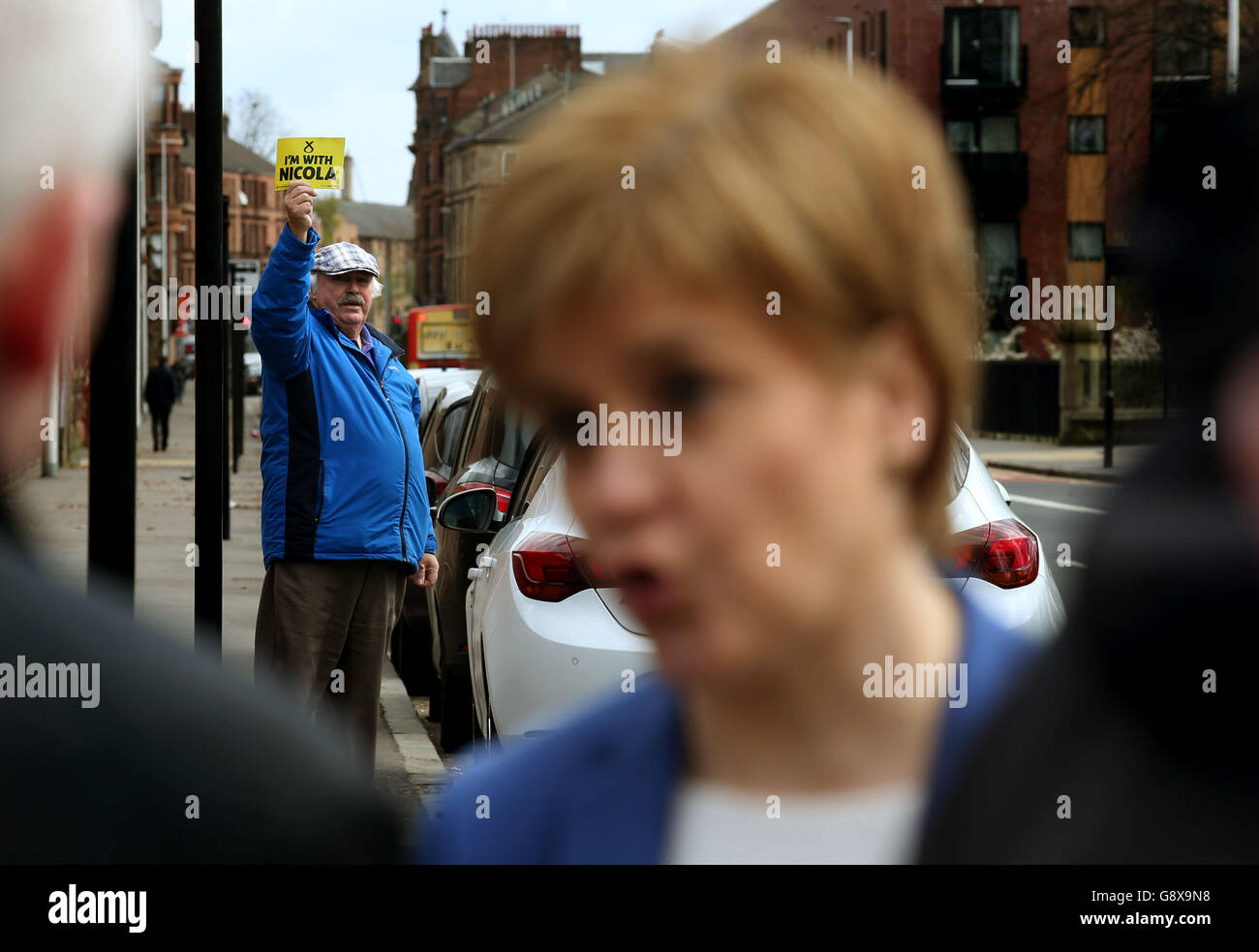 Un sostenitore della SNP ha un cartello, in quanto il leader della SNP e il primo ministro Nicola Sturgeon si trova alle porte della BAE Systems presso il cantiere Govan di Glasgow, dove ha incontrato rappresentanti dei sindacati durante la campagna elettorale scozzese. Foto Stock