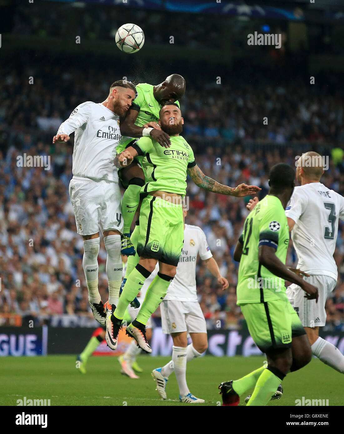 Eliaquim Mangala (centro) di Manchester City e Nicolas Otamendi salti per una testata con Sergio Ramos del Real Madrid durante la semifinale della UEFA Champions League, seconda tappa al Santiago Bernabeu di Madrid. Foto Stock