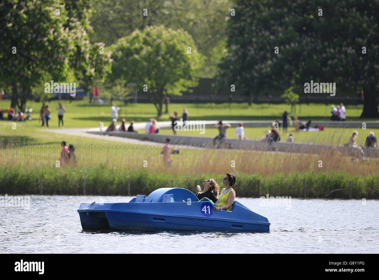 I visitatori di Hyde Park fanno un giro in barca a pale lungo la serpentina, Londra, dato che ha finalmente avuto l'impressione che la primavera sia arrivata nell'ultima settimana o così via, con gran parte del Regno Unito godendo di alcune condizioni belle e calde. Foto Stock