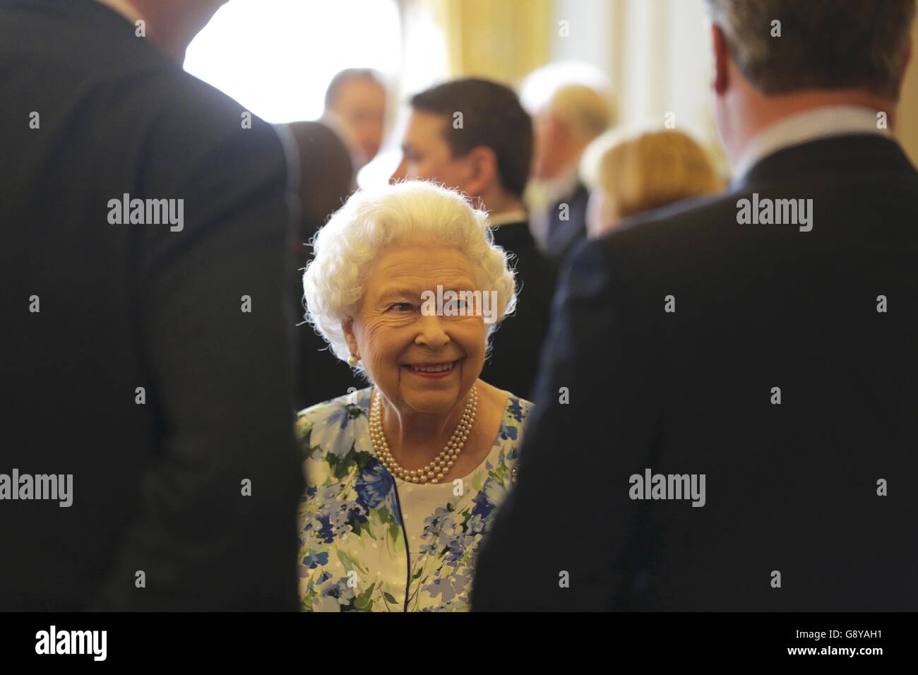 La regina Elisabetta II parla al primo ministro David Cameron durante un ricevimento a Buckingham Palace, Londra, per celebrare il 90° compleanno della regina. Foto Stock