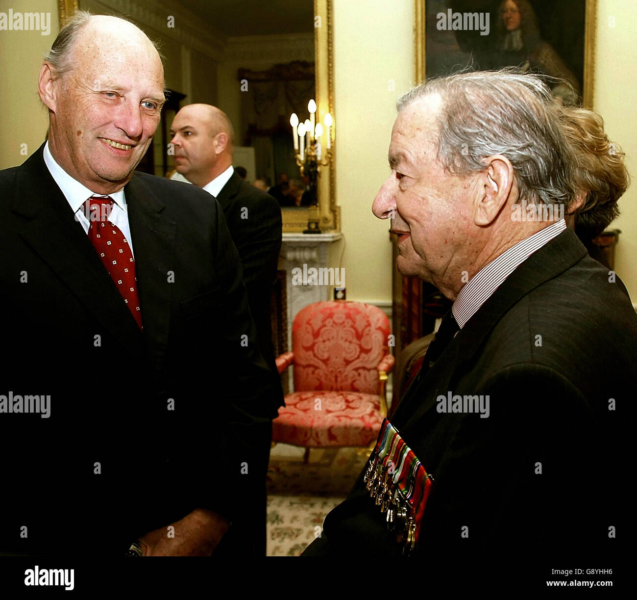 Il re norvegese Harald (a sinistra) parla ai veterani militari della seconda guerra mondiale a Buckingham Palace, Londra, durante un ricevimento in occasione del 60° anniversario della Liberazione della Norvegia, martedì 25 ottobre 2005. Vedi PA Story ROYAL Norway. PREMERE ASSOCIAZIONE foto. Il credito fotografico dovrebbe essere: PA/Max Nash/AFP/WPA Rota Foto Stock