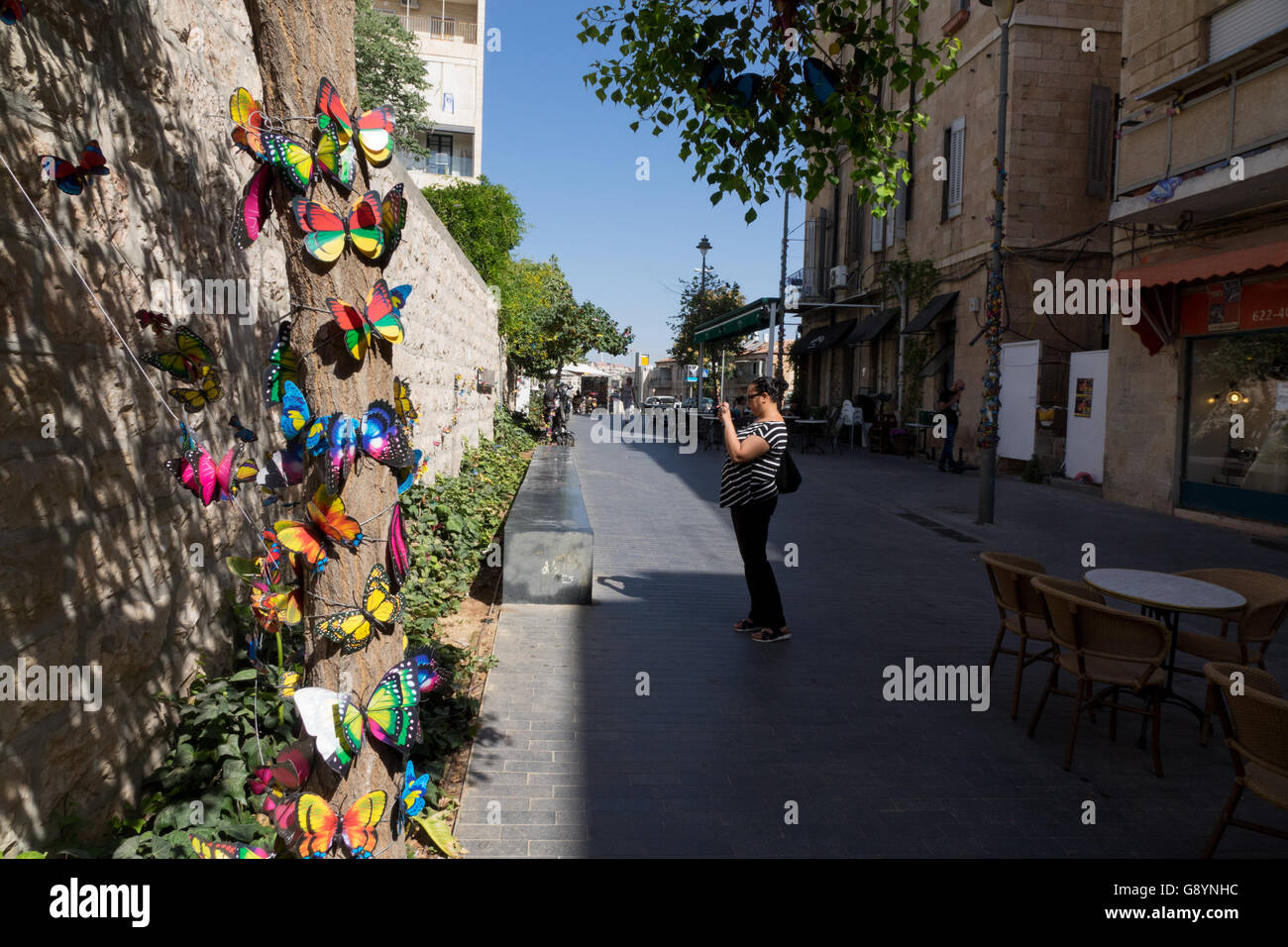 Gerusalemme, Israele. Il 30 giugno, 2016. Una donna di fotografare le farfalle artificiale che decorano Bezaleel street a Gerusalemme. Credito: Valentin Sama-Rojo/Alamy Live News. Foto Stock