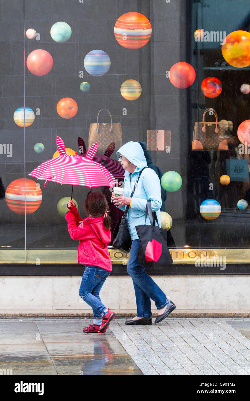 Manchester, Regno Unito. 1 Luglio, 2016. Regno Unito: atmosferiche torrenziali acquazzoni pesanti di pioggia immergere gli amanti dello shopping nel centro della città di Manchester. Le perturbazioni atmosferiche in tutto il nord-ovest dell'Inghilterra catturato gli acquirenti di sorpresa con pesanti rigurgiti di pioggia questo pomeriggio. Alcuni sono stati preparati ma altri utilizzano tecniche alternative per mettersi al riparo. Credito: Cernan Elias/Alamy Live News Foto Stock