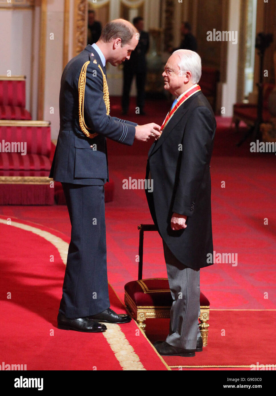 L'ex giornalista televisivo Sir Martyn Lewis riceve un cavaliere dal duca di Cambridge durante una cerimonia di investitura a Buckingham Palace, Londra. Foto Stock