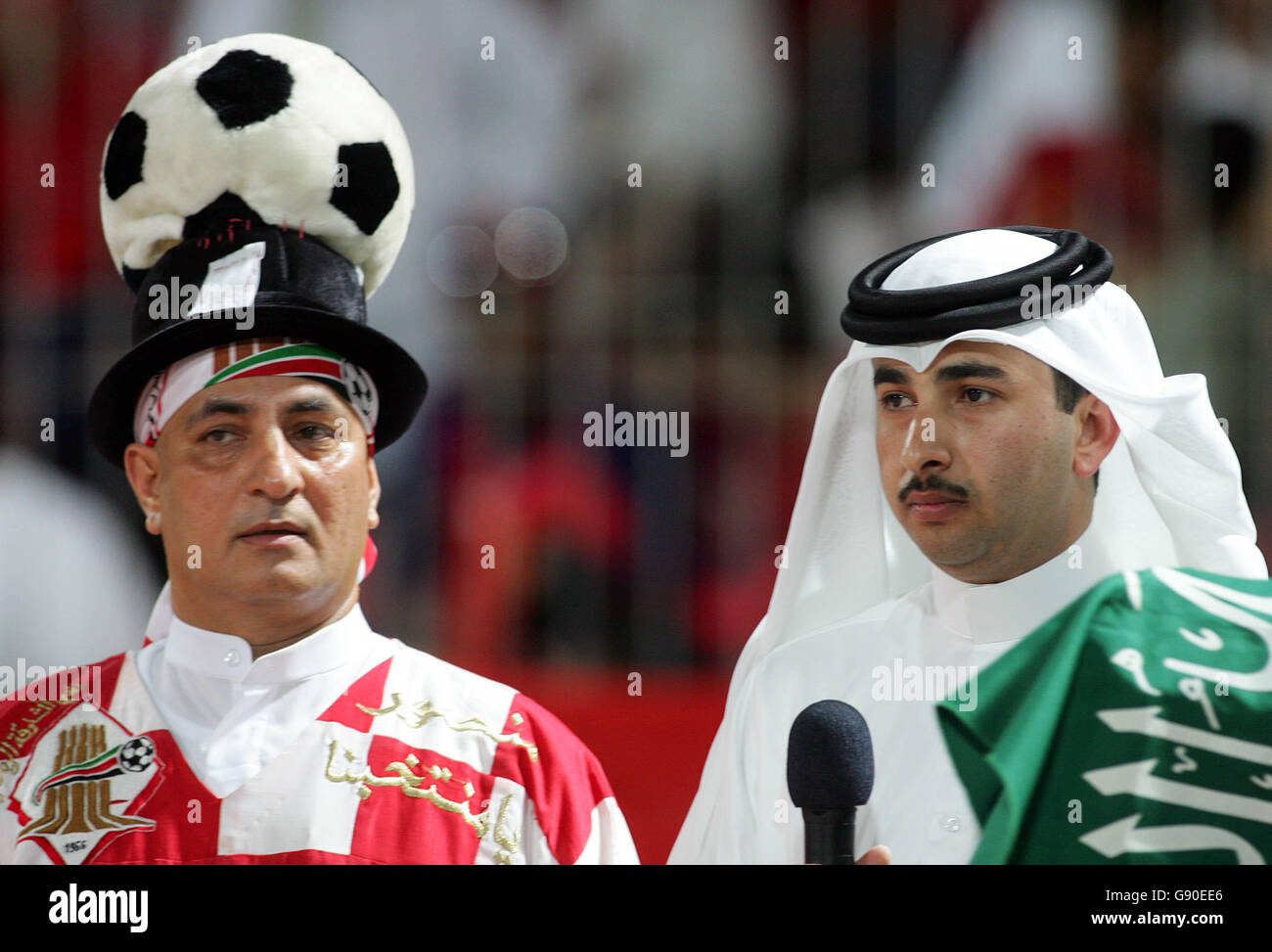 Calcio - 2006 FIFA World Cup Qualifier, - Bahrain contro Trinidad e Tobago, Gioca fuori, seconda tappa - Stadio Nazionale, Bahrain. Un giornalista del Bahrain vestito in modo tradizionale attende di parlare con un fan del Bahrain Foto Stock