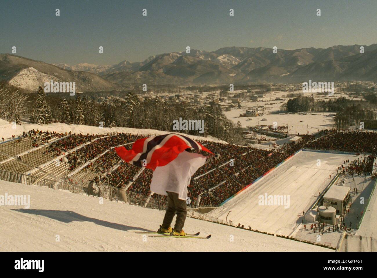 Sci Jumping - Olimpiadi invernali - Nagano 1998 - 90m evento individuale. Un Forward Runner inizia la discesa del corso di salto con la bandiera norvegese Foto Stock