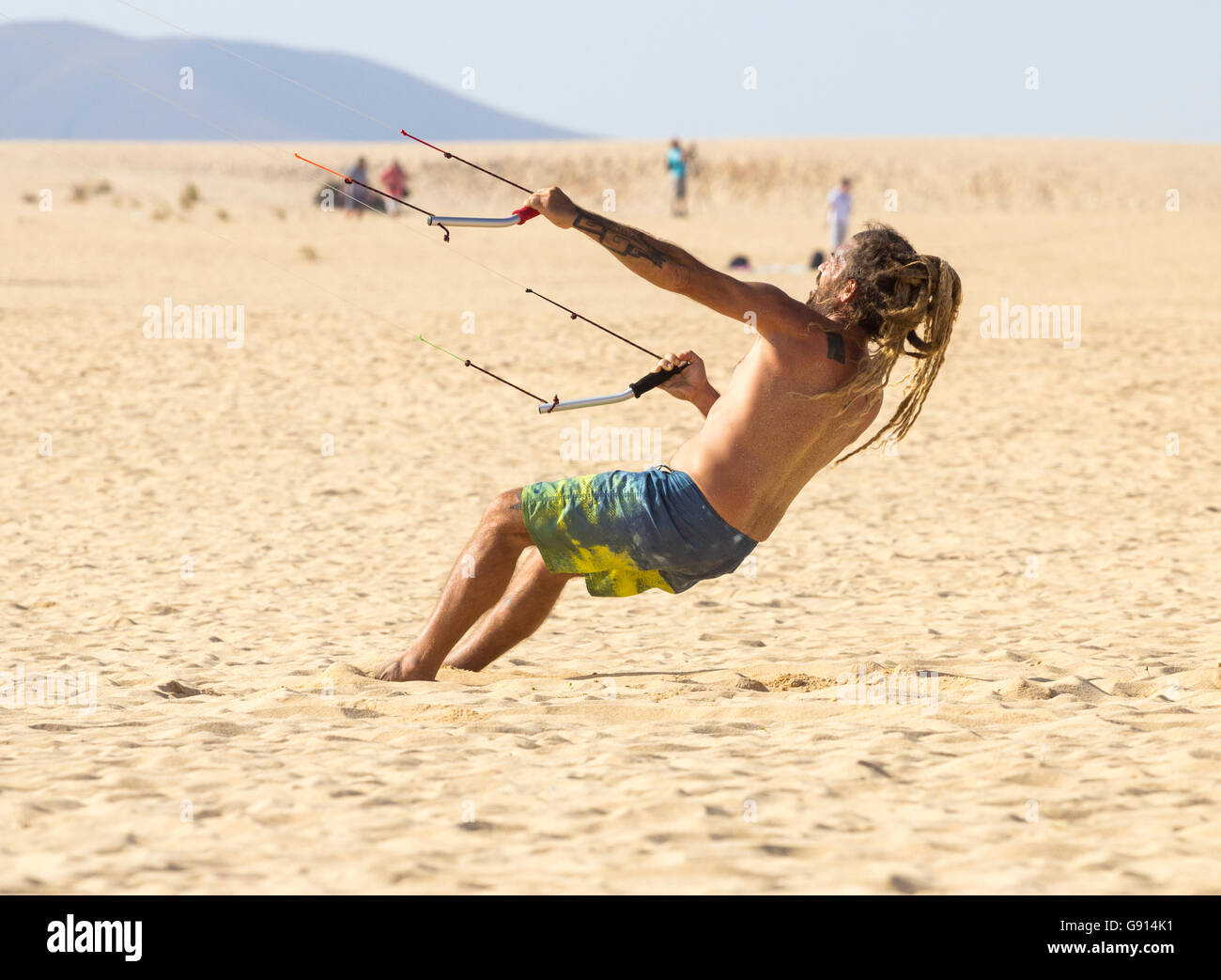 Uomo con dreadlocks aquilone volante sulla spiaggia di Corralejo a Fuerteventura, Isole Canarie, Spagna Foto Stock