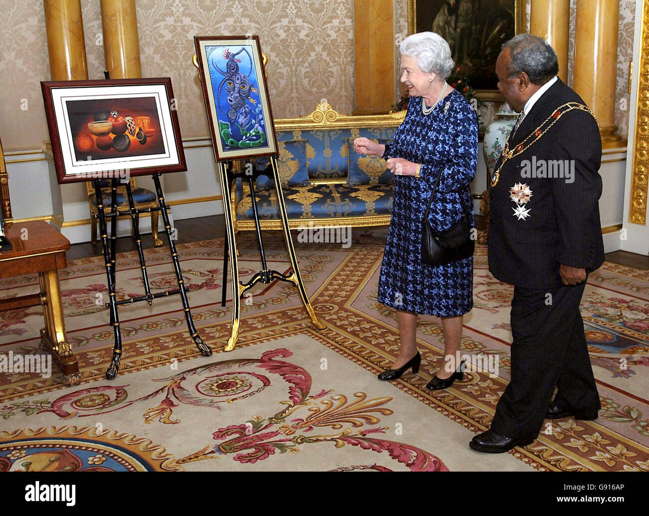 La Regina Elisabetta II della Gran Bretagna e il primo Ministro della Papua Nuova Guinea il Rt. L'on. Sir Michael Somare guarda un dono di due dipinti per la Regina a Buckingham Palace, Londra, Martedì 22 novembre, 2005. Sir Michael ha anche presentato alla Regina il distintivo del Sovrano dell'Ordine di Logohu. PREMERE ASSOCIAZIONE foto. Il credito fotografico dovrebbe essere: Matthew Fearn/WPA Rota/PA Foto Stock